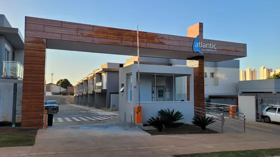 Portaria do condomínio com os sobrados ao fundo (foto real)
